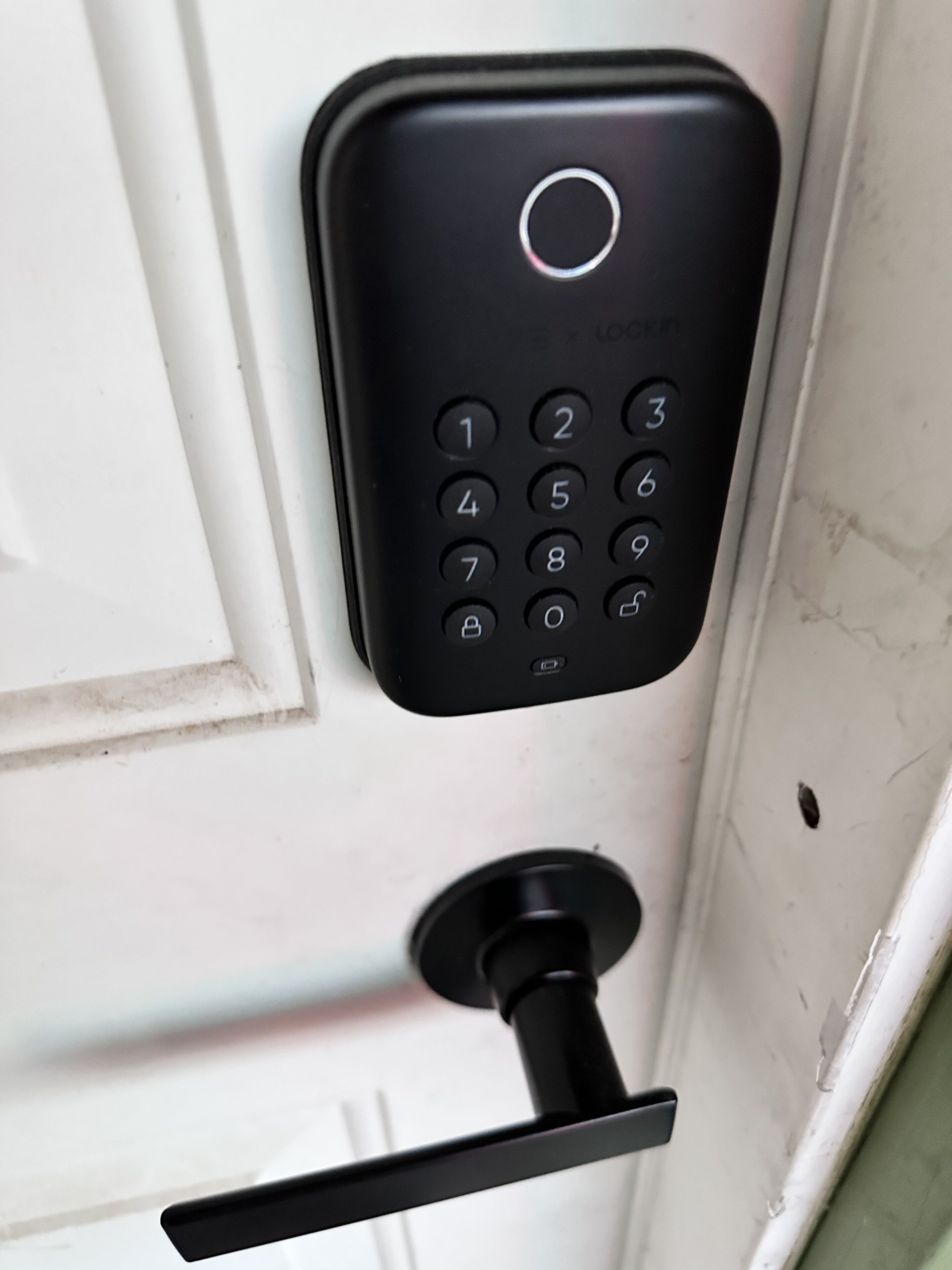 Une porte dotée d’une serrure électronique à clavier noir.