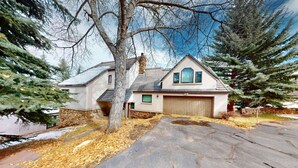 A two-story house with a stone foundation, a garage, and a driveway. - Large Family Home - Beaver Creek (Avon)