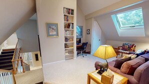 A cozy living room with a sofa, a table, a lamp, and a bookshelf. - Large Family Home - Beaver Creek (Avon)