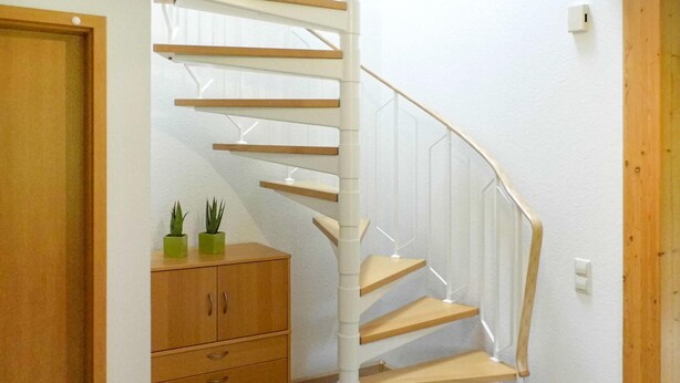 A spiral staircase with wooden steps and white railings, leading to an upper floor. - 3 bedroom beautiful home in Kirchheim (Kirchheim)