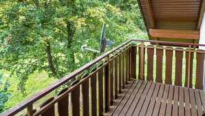 A wooden deck with a metal railing overlooking a forested area. - 3 bedroom beautiful home in Kirchheim (Kirchheim)
