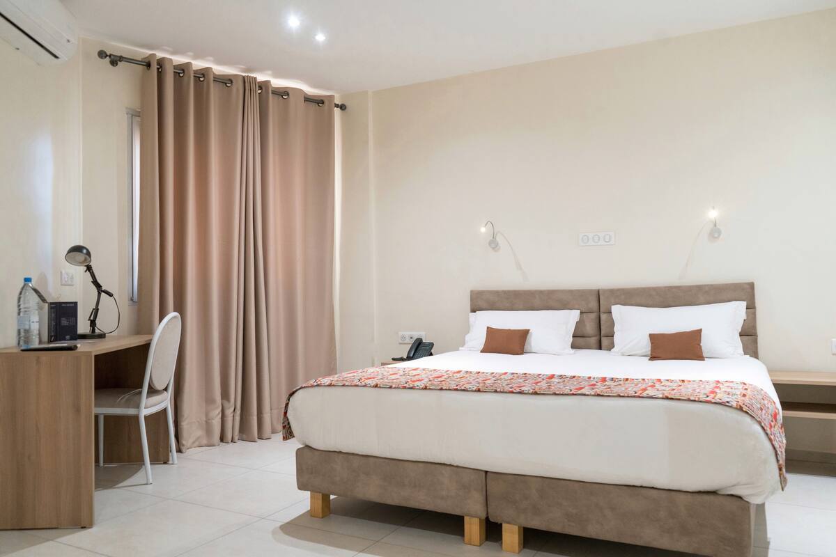 A bedroom with a bed, a desk, and a chair.