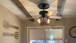 A dining area with a round table, four chairs, a ceiling fan, and a clock on the wall. - Peaceful country farmhouse. Located 5 minutes from Historic downtown Post! (Post)