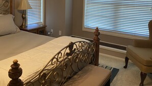 A bedroom with a bed, a bench, a chair, a lamp, and a ceiling fan. - Peaceful country farmhouse. Located 5 minutes from Historic downtown Post! (Post)