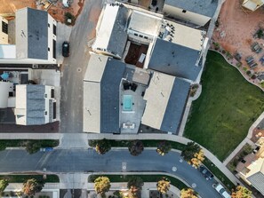 An aerial view of a residential area with multiple buildings, a swimming pool, and a well-maintained lawn.