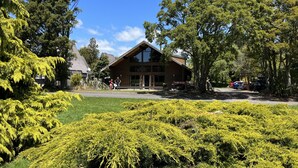 Eine Lodge mit markantem Holzbau, umgeben von üppiger Vegetation und Bäumen.