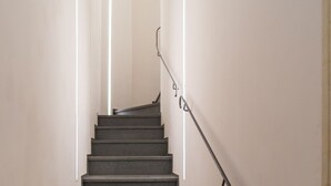 Una escalera con barandilla y luces en las paredes.