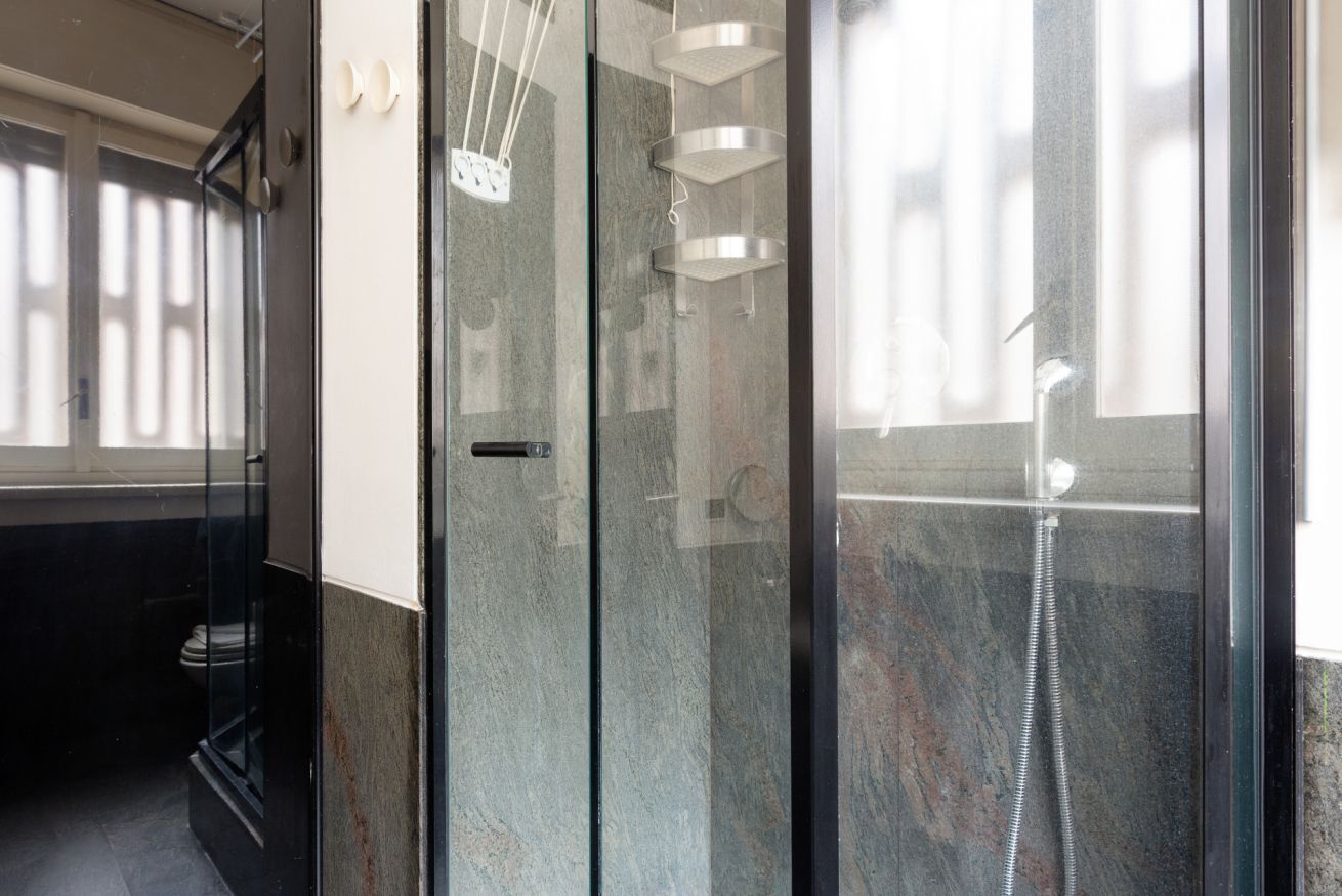 Une salle de bain moderne avec une douche à parois de verre, des toilettes et un lavabo.