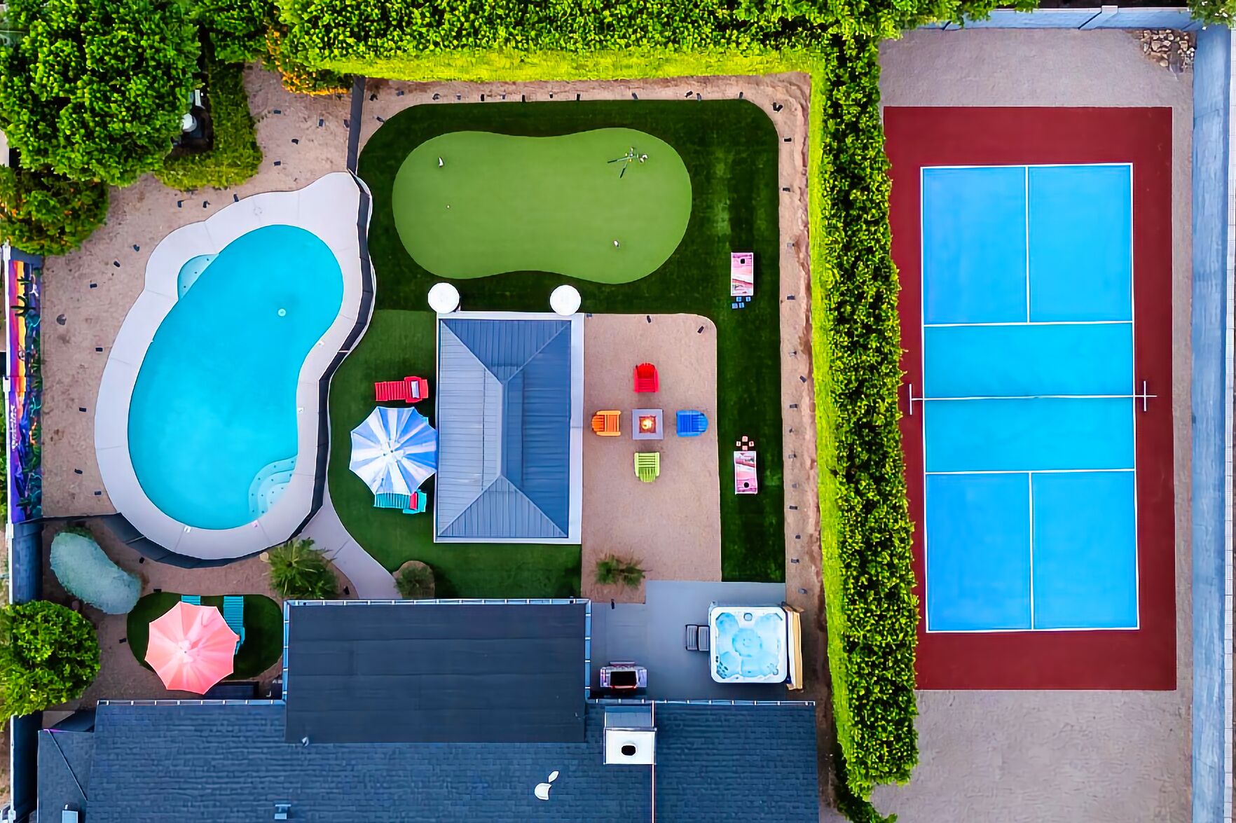 Backyard oasis with pool, hot tub, pickleball, putting green, and fire pit.

