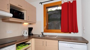 A compact kitchen with a microwave, coffee maker, and a dishwasher. - Sleeps 8 | 2BR Alcove in Prime Ski Location! (Valmeinier)