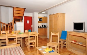 Cozy living space with a dining table, kitchen area, and TV, perfect for a comfortable stay.