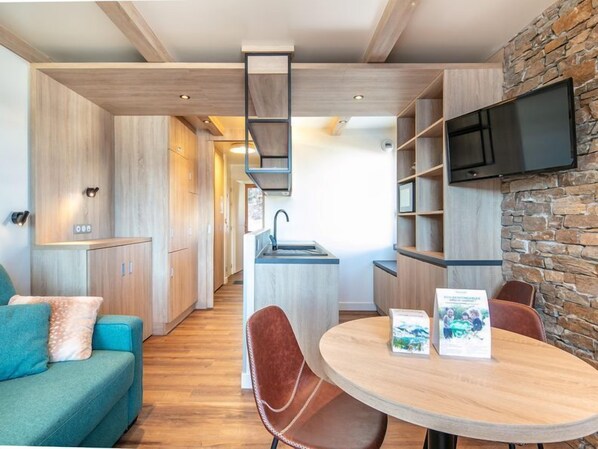 Una cocina moderna con armarios de madera, un lavamanos empotrado y una pared decorativa de piedra.