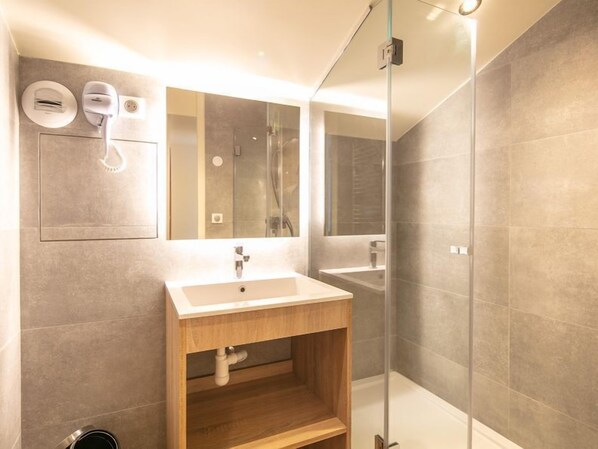A modern bathroom with a wooden vanity, a large mirror, and a glass shower enclosure. - Valmorel | 2BR for 10 + Ski-in, Ski-out! (Doucy)