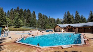 Ein Swimmingpool mit blauem Himmel und Bäumen im Hintergrund.