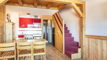 Un intérieur en bois comprenant un coin repas, une cuisine et un escalier.