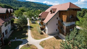 A resort with multiple buildings, a central courtyard, and a mountainous backdrop.