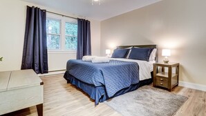 A bedroom with a bed, bedside tables, a chair, and a window with curtains. - Premier League Pad - with Free Parking, Heat & AC (Manchester)