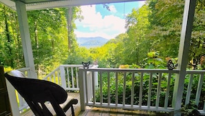 A wooden deck with a white railing, overlooking a lush green landscape with trees and a mountain in the distance. - Gorgeous, cozy, private retreat - Hot tub, views, CLOSE TO EVERYTHING. 43 acres! (Banner Elk)