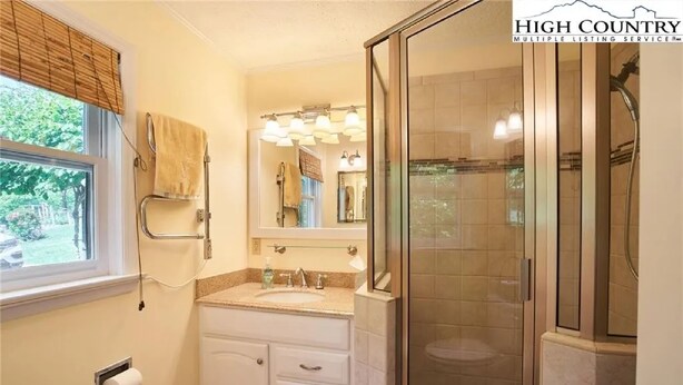 A bathroom with a glass-enclosed shower, a vanity with a sink, and a toilet. - Gorgeous, cozy, private retreat - Hot tub, views, CLOSE TO EVERYTHING. 43 acres! (Banner Elk)