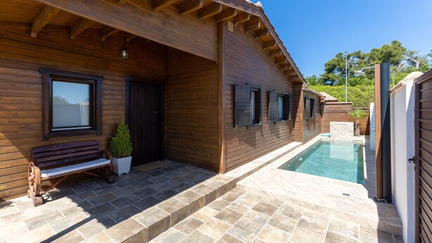 A wooden building with a pool, a bench, and a potted plant. - Rural House 'La Dehesa2' in Toledo with Private Pool, Wi-Fi, and Air Conditioning (Cobisa)