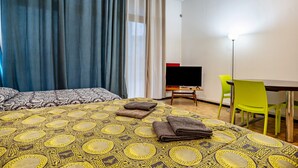 A hotel room with a bed, a desk, a chair, and a TV. - Apartment 'Trento Degasperi 16' with Wi-Fi (Trento)