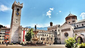 A historic building with a prominent clock tower, a fountain, and a statue. - Apartment 'Trento Degasperi 16' with Wi-Fi (Trento)