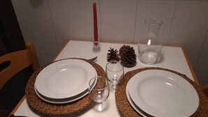 A dining table set with plates, cutlery, glasses, and decorative items.