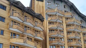 A multi-story wooden building with balconies, likely a hotel or residential complex.