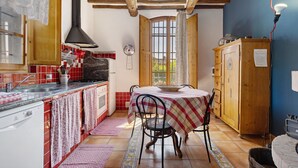 A kitchen with a dining table, chairs, and a wooden cabinet. - Holiday Home 'La Ripa - Appartamento I Nidi' with Shared Pool, Garden & Wi-Fi (San Gimignano)