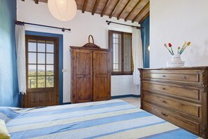 A bedroom with a bed, wooden wardrobe, and a dresser. - Holiday Home 'La Ripa - Appartamento I Nidi' with Shared Pool, Garden & Wi-Fi (San Gimignano)