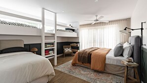 Een moderne slaapkamer met een stapelbed, een bureau en een leeslamp.