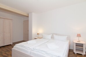 A bedroom with a bed, bedside tables, and a wardrobe.