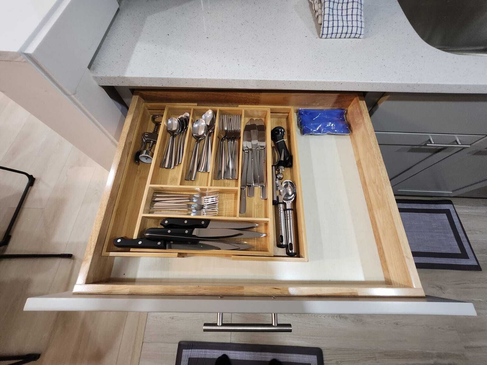 Eine Schublade mit Besteck und einem Messerblock.