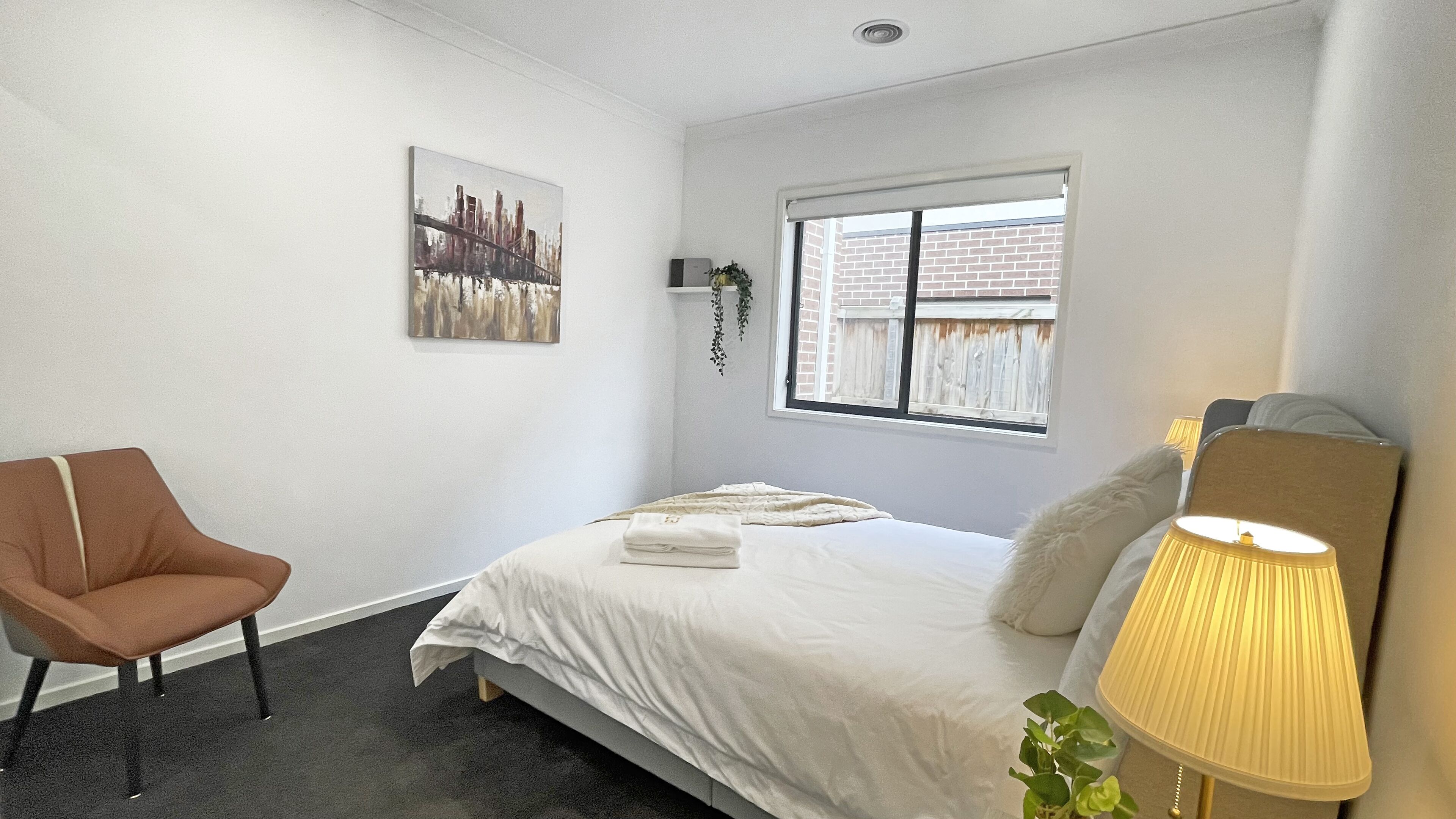 Une chambre à coucher avec un lit, une chaise, une fenêtre et une lampe.