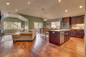 A spacious kitchen with wooden flooring, a central island, and built-in cabinets.