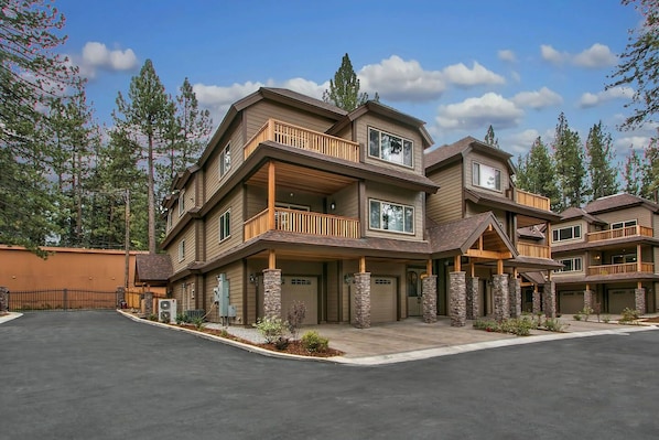 A multi-story residential building with a central courtyard, stone pillars, and a gated entrance.