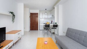 A modern apartment with a living room, kitchen, and dining area.