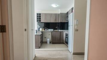 A modern kitchen with wooden cabinets, a built-in oven, and a sink.