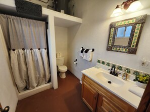 Een douche, handdoeken, zeep, toiletpapier