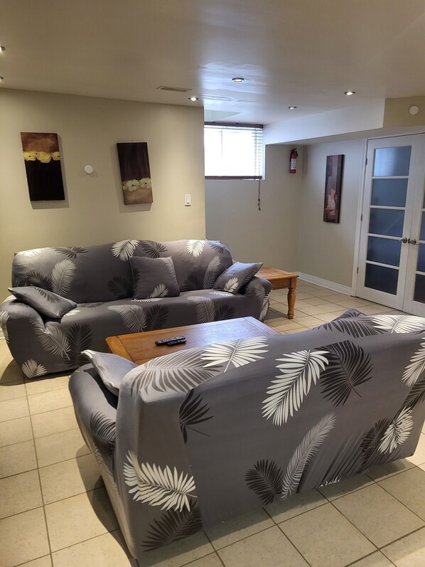 A living room with a grey sofa set, a wooden coffee table, and a small side table.
