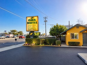 A motel with a large sign advertising clean rooms, color cable TV, and kitchenettes. - Oak Motel Modesto CA (Modesto)