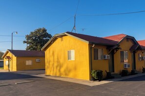 A yellow building with a red roof, a visible satellite dish, and a clear blue sky. - Oak Motel Modesto CA (Modesto)