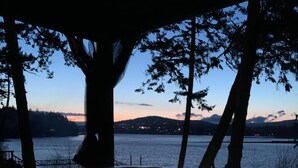 A hot tub with a view of a lake and mountains at dusk. - Sooke Waterfront Retreat – Hot Tub & Dock Access (Sooke)