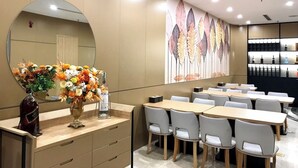 A modern restaurant with a long counter, multiple tables, and a large mirror. - Milash Boutique Hotel (Bai Chay)