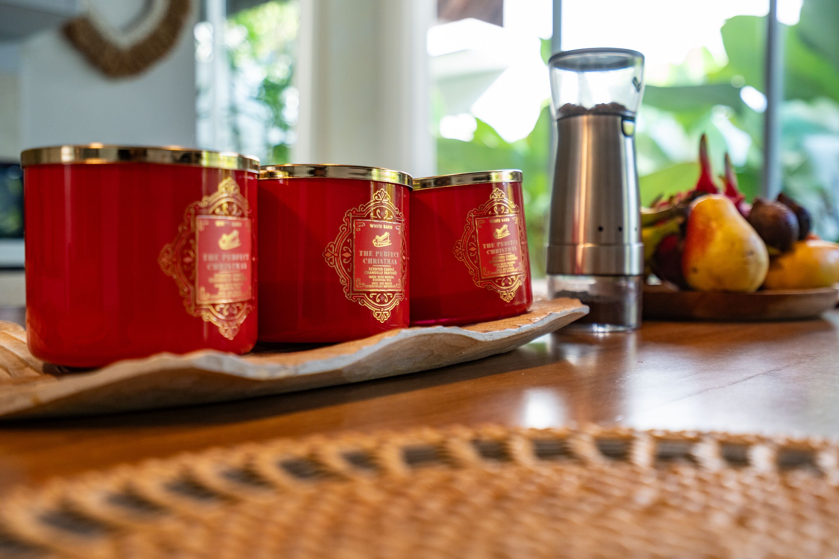 Three red containers with gold detailing on a wooden tray.