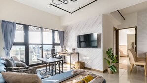 A modern living room with a sofa, coffee table, and a TV mounted on the wall. - High Floor New Bldg 5★ Ximending, Stunning Views (Taipei City)
