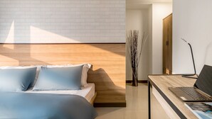 A bedroom with a bed, a desk with a laptop, and a door leading to another room. - High Floor New Bldg 5★ Ximending, Stunning Views (Taipei City)