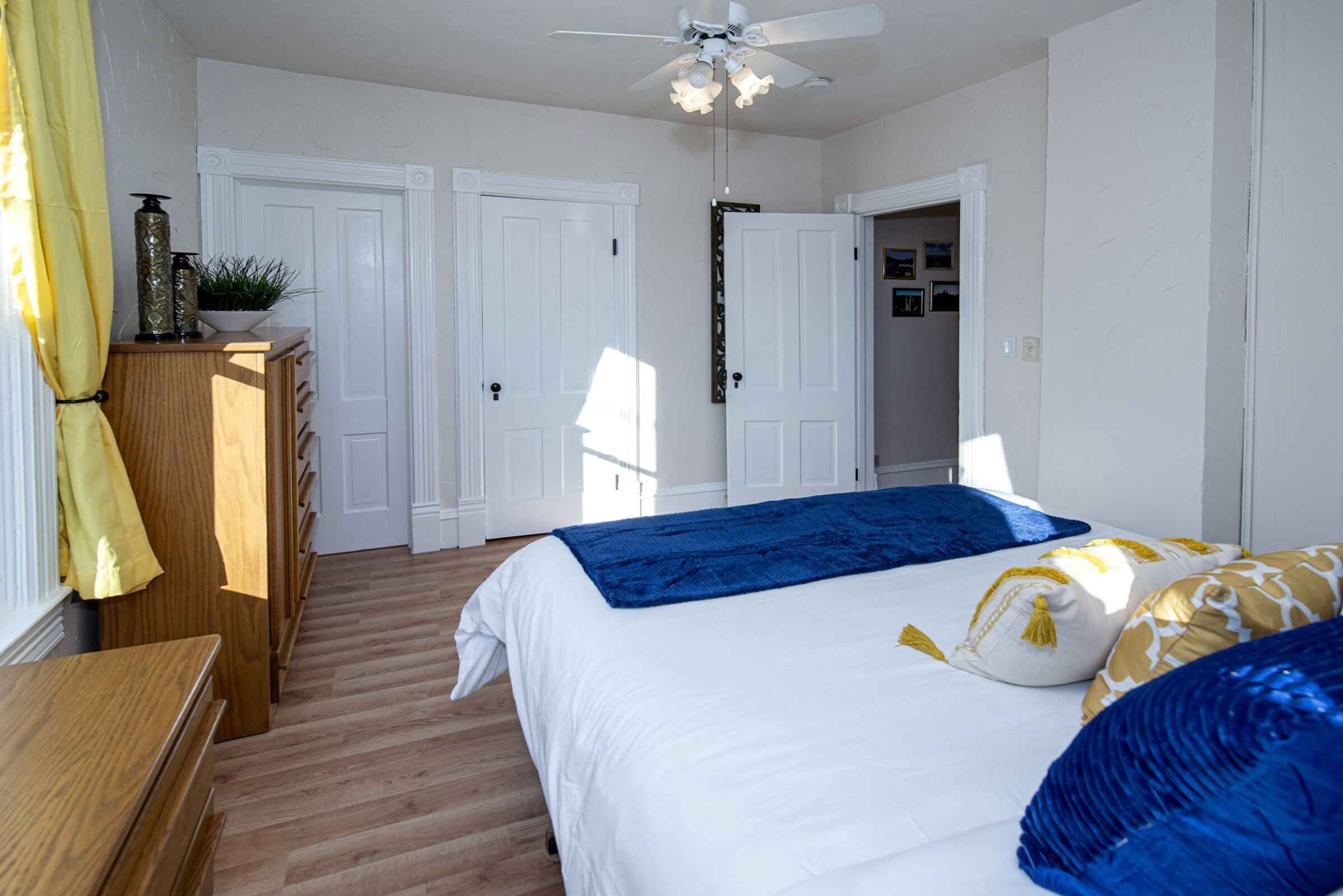 Ein Schlafzimmer mit einem Bett, einem Holzschrank und einem Deckenventilator.