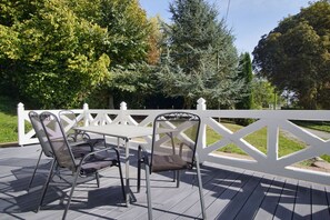 An outdoor patio with a white fence, a table, and two chairs. - Ruhig und Idyllische Lage, Ahoi Erlebnisbad Gratis - Gutshaus Silvitz Fewo 02 - Gutshaus Silvitz (Bergen auf Rügen)
