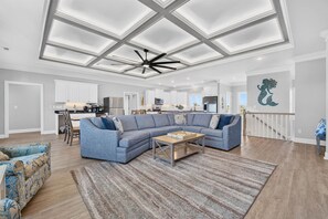 A spacious living room with a sectional sofa, a coffee table, and a patterned rug.
